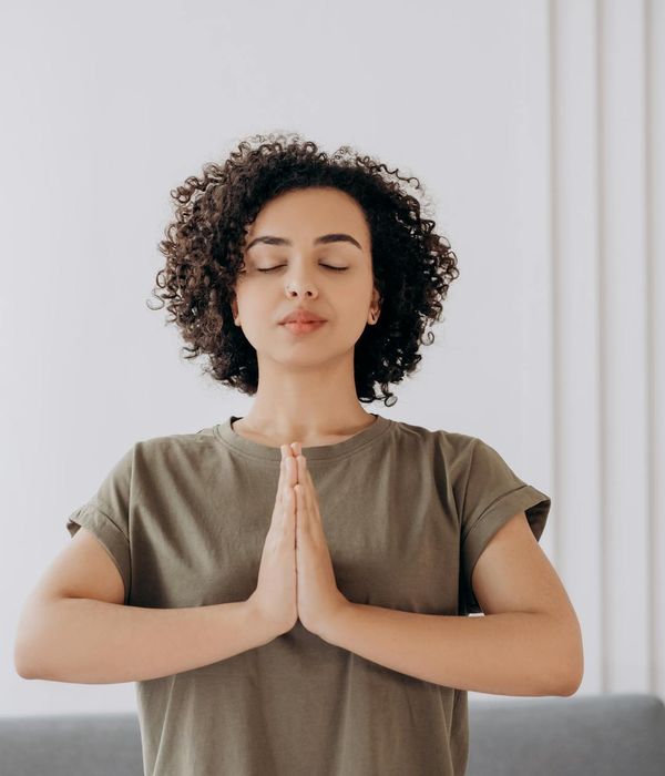 Serene woman practicing soft focus eye exercises outdoors.